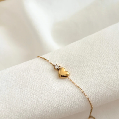 Pulseira dourada com pendente de coração e cristal