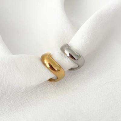 Dois anéis, um dourado e outro prateado, em tecido branco