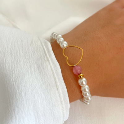 Pulseira de pérolas com coração dourado e conta rosa no pulso