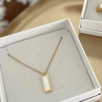 Colar dourado com pendente retangular branco em caixa branca