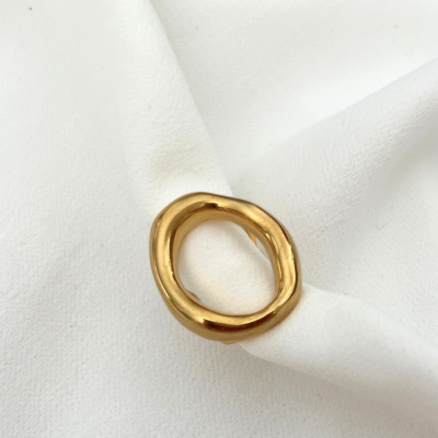 Anel dourado sobre tecido branco