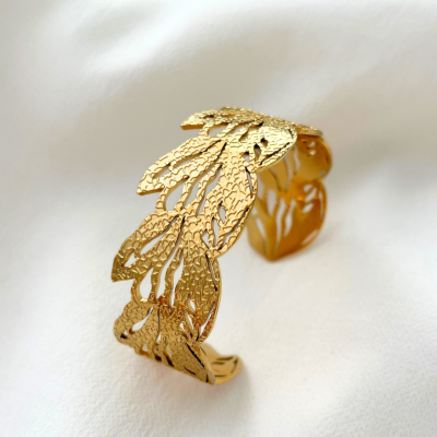 Pulseira dourada em metal com design de folhas recortadas