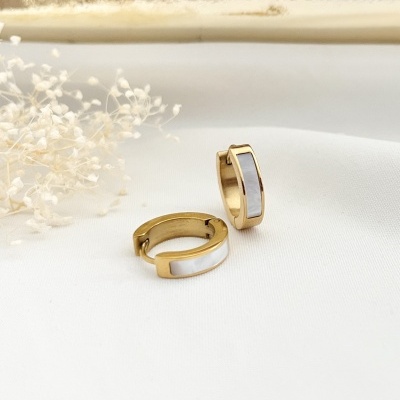 Brincos de argola pequenos dourados com faixa branca, sobre tecido branco