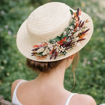 Chapéu de palha decorado com flores secas coloridas visto de trás