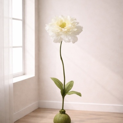 Flor artificial branca em vaso verde no chão, junto a uma janela com cortina branca