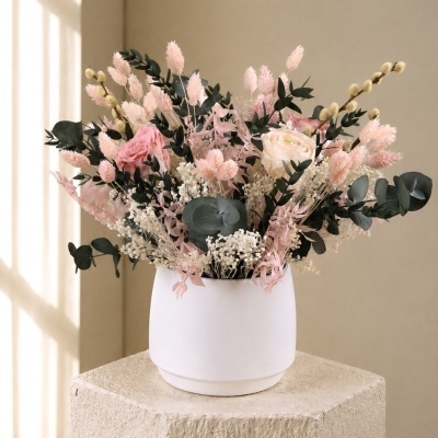Arranjo floral em vaso branco com flores rosas e verde