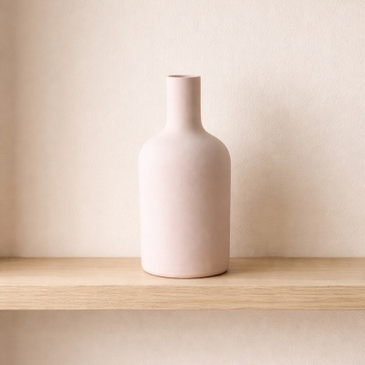 Vaso decorativo de cerâmica rosa clara numa prateleira de madeira