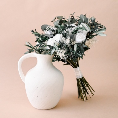Vaso branco de cerâmica com bouquet de flores brancas e verdes