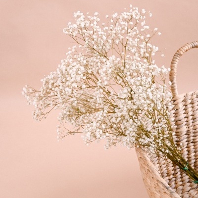 Cesto trançado de palma com flores pequenas brancas
