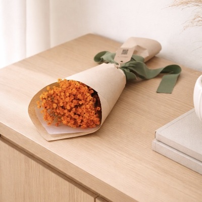 Bouquet de flores secas laranja em papel castanho com fita verde