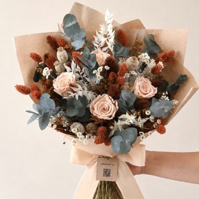 Buquê de flores secas e preservadas em tons de rosa, azul e terracota