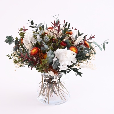 Arranjo floral com flores brancas, vermelhas e laranjas em vaso de vidro