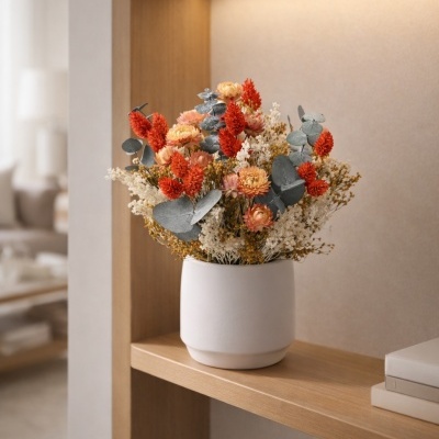 Arranjo de flores secas em vaso branco numa prateleira de madeira clara