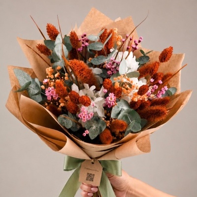 Buquê de flores secas em embalagem de papel kraft com laço verde e etiqueta TERRACOTTA