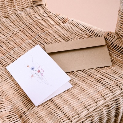 Cartão de flores e envelope em cadeira de vime