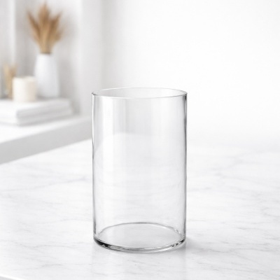 Vaso cilindrico de vidro transparente sobre mesa de marmore branco