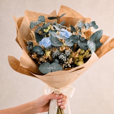 Buquê de flores com rosas azuis e folhas de eucalipto embrulhado em papel kraft