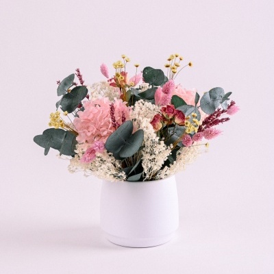 Arranjo floral em vaso branco com flores secas coloridas