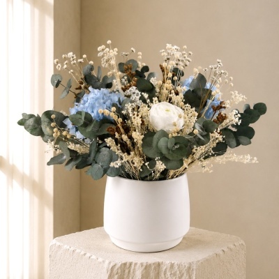 Arranjo de flores secas e artificiais em vaso branco fosco