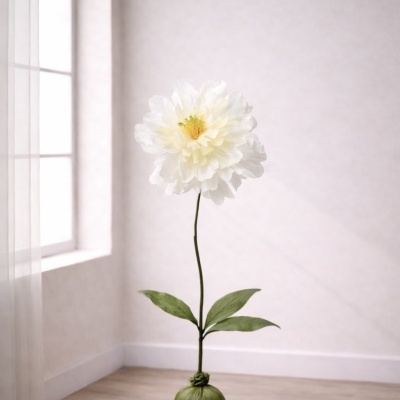 Flor artificial branca com folhas verdes em saco verde no chão junto a janela