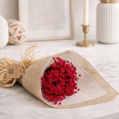 Buquê de flores vermelhas em papel rústico com tag TERRACOTTA sobre bancada de mármore