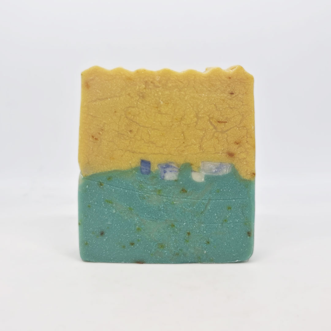 Sabonete de Cardamomo e Mimosa Sabonete artesanal amarelo e verde-azulado com textura irregular