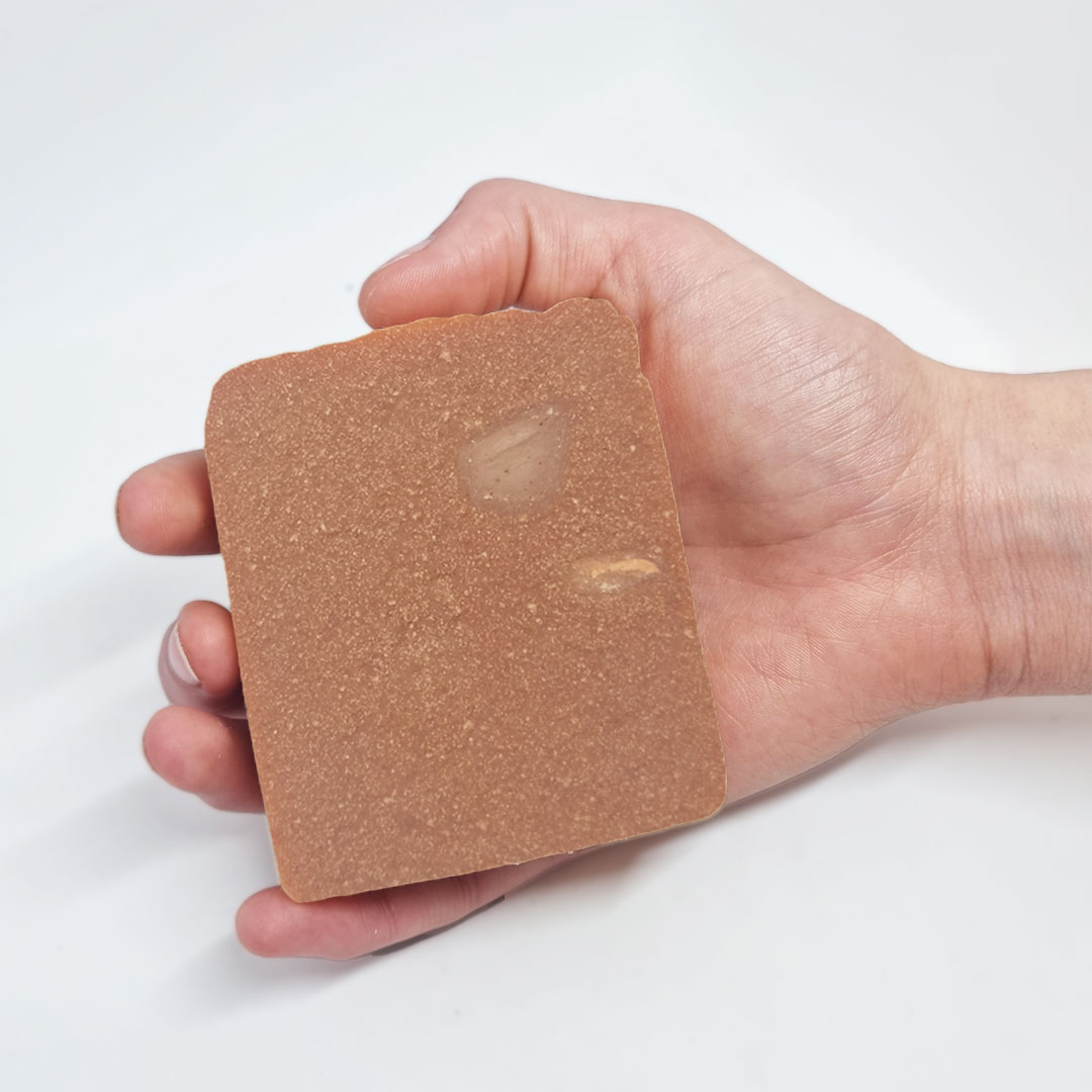 Sabonete Lavanda Patchouli Pedra retangular marrom com textura rugosa numa mão