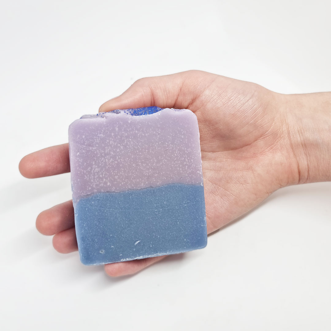 Sabonete Lírios e Musk Sabonete quadrado bicolor lilás e azul numa mão