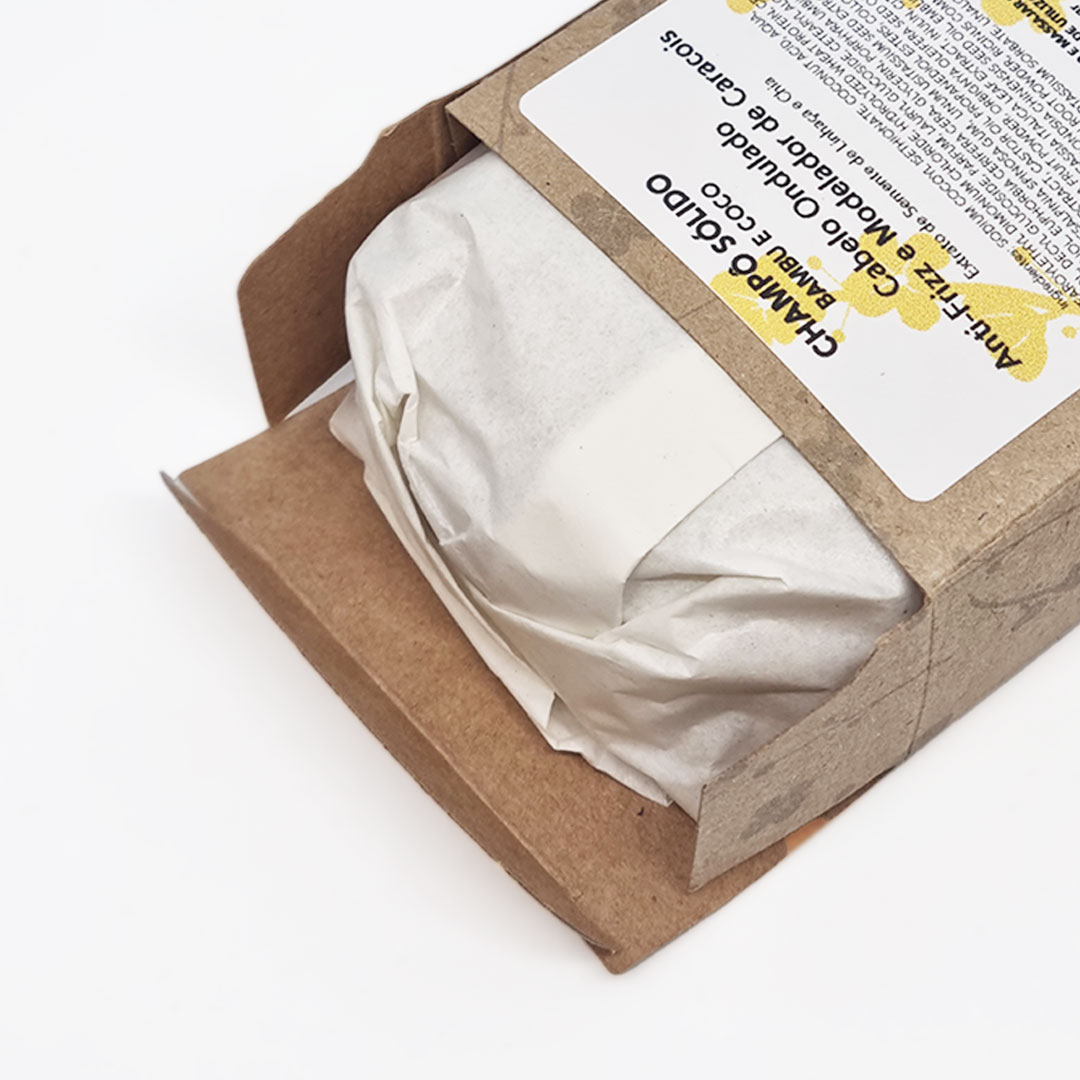 Champô Sólido Cabelo Ondulado - Bambu e Coco Embalagem de papel castanho e produto embrulhado em papel branco com etiqueta escrita CHÁRIO SOLIDO BAMBU COCO