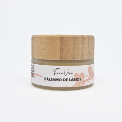 Frasco de bálsamo de lábios com tampa de madeira e etiqueta branca com texto e desenho floral