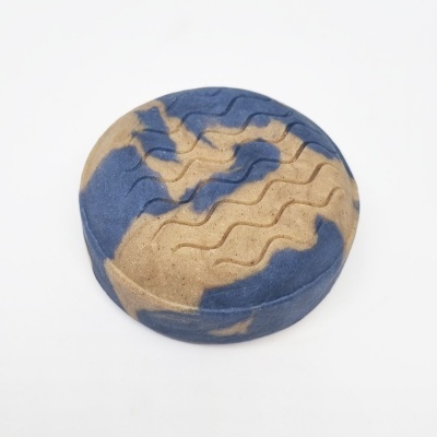 Sabonete redondo azul e bege com padrão ondulado