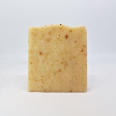 Sabão artesanal bege com manchas castanhas sobre fundo branco