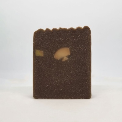 Barra de chocolate retangular castanha com inclusões claras sobre fundo branco