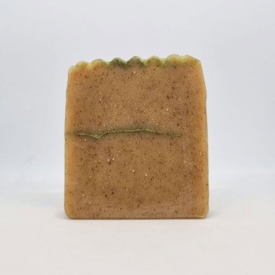 Sabonete rectangular bege com granulados e linha verde no centro