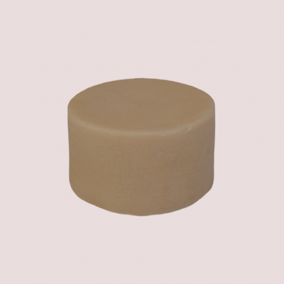 Forma redonda de queijo bege sobre fundo rosa claro