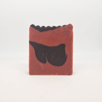 Sabonete artesanal vermelho com detalhes pretos e textura granulada
