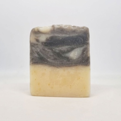 Sabonete retangular bicolor bege e cinzento com textura rugosa no topo