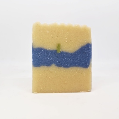 Sabonete artesanal bege com faixa azul e detalhe verde