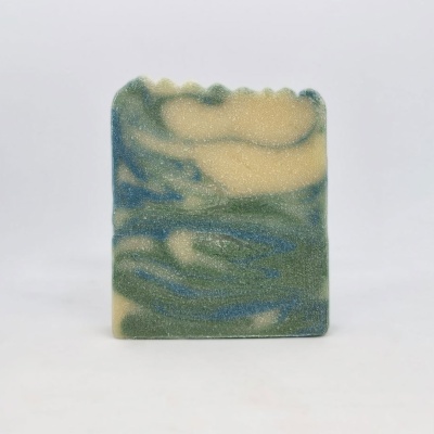 Sabonete artesanal marmoreado azul, verde e bege sobre fundo branco