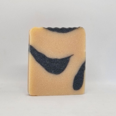 Sabonete artesanal bege com manchas pretas em fundo branco