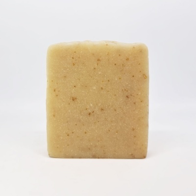 Sabonete quadrado bege com textura granulada em fundo branco