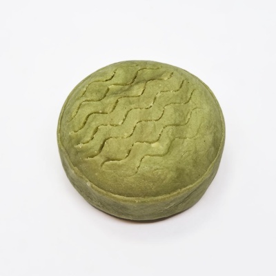 Queijo redondo verde com padrão ondulado em relevo