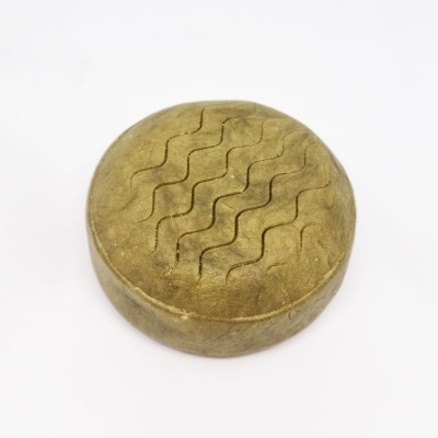 Sabonete redondo amarelo com textura ondulada