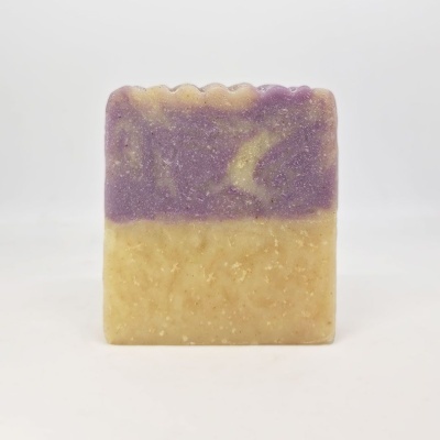 Sabonete artesanal bicolor roxo e bege com textura e padrão ondulado