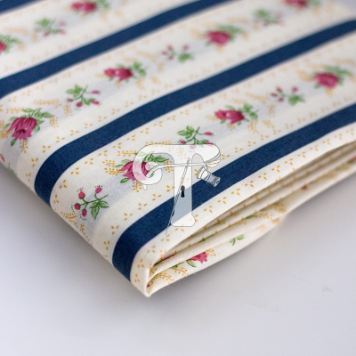 Tecido dobrado com padrão de listra azul escura e flores pequenas rosa