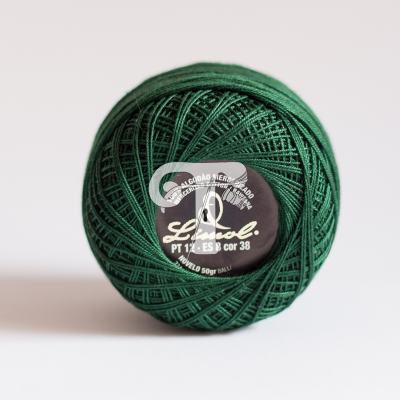 Rolo de linha verde escuro com etiqueta preta e texto branco