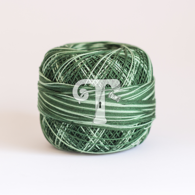 Rolo de linha verde com diferentes tons e texturas sobre fundo branco