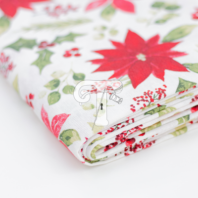 Tecido dobrado com padrão floral vermelho e verde sobre fundo branco