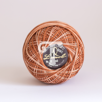 Rolo de linha castanho claro com etiqueta preta e texto branco e amarelo.