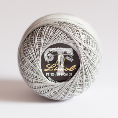 Rolo de linha de algodão cinza claro com etiqueta preta e dourada